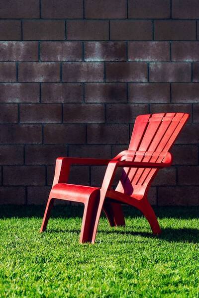 silla roja de plástico sobre el césped